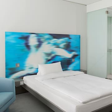 a bed with a blue and white picture on the wall