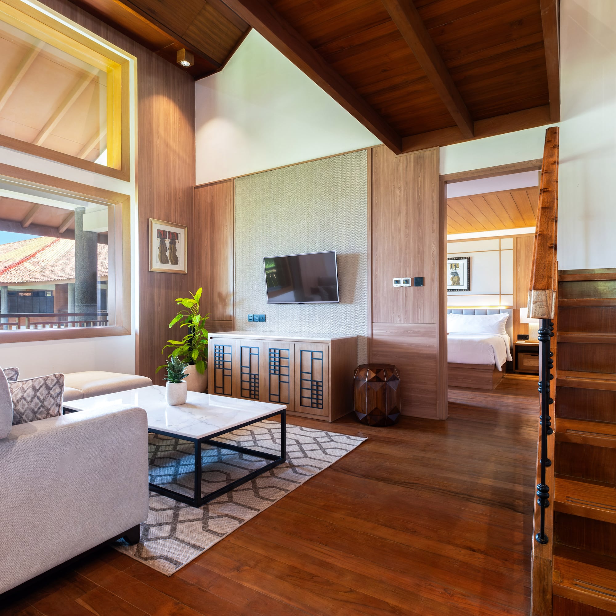 a living room with a wood floor and a wood staircase
