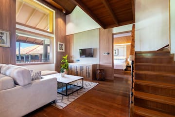 a living room with a wood floor and a wood staircase
