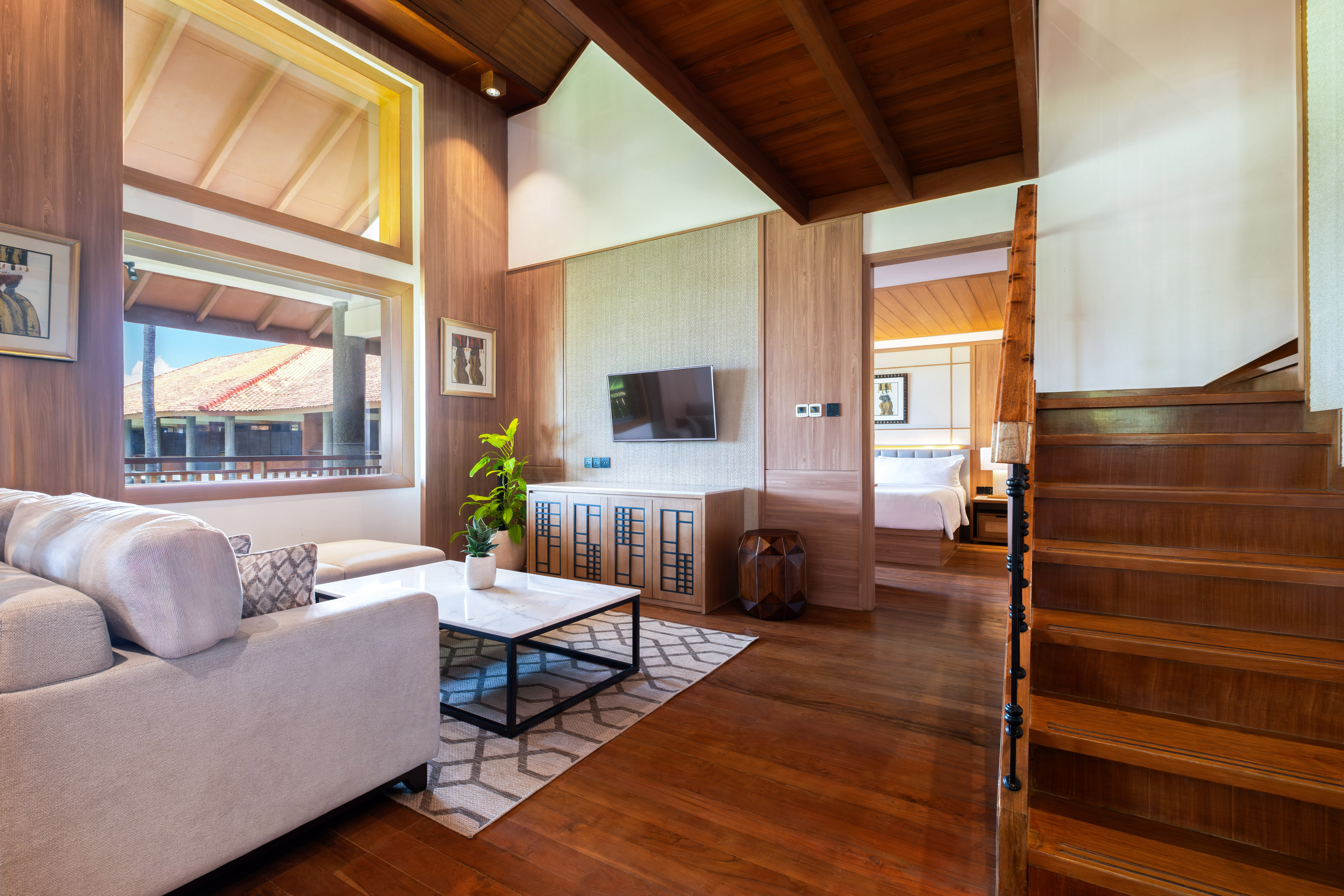 a living room with a wood floor and a wood staircase