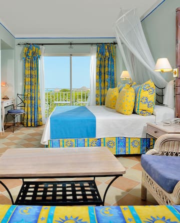 a room with a bed and chairs