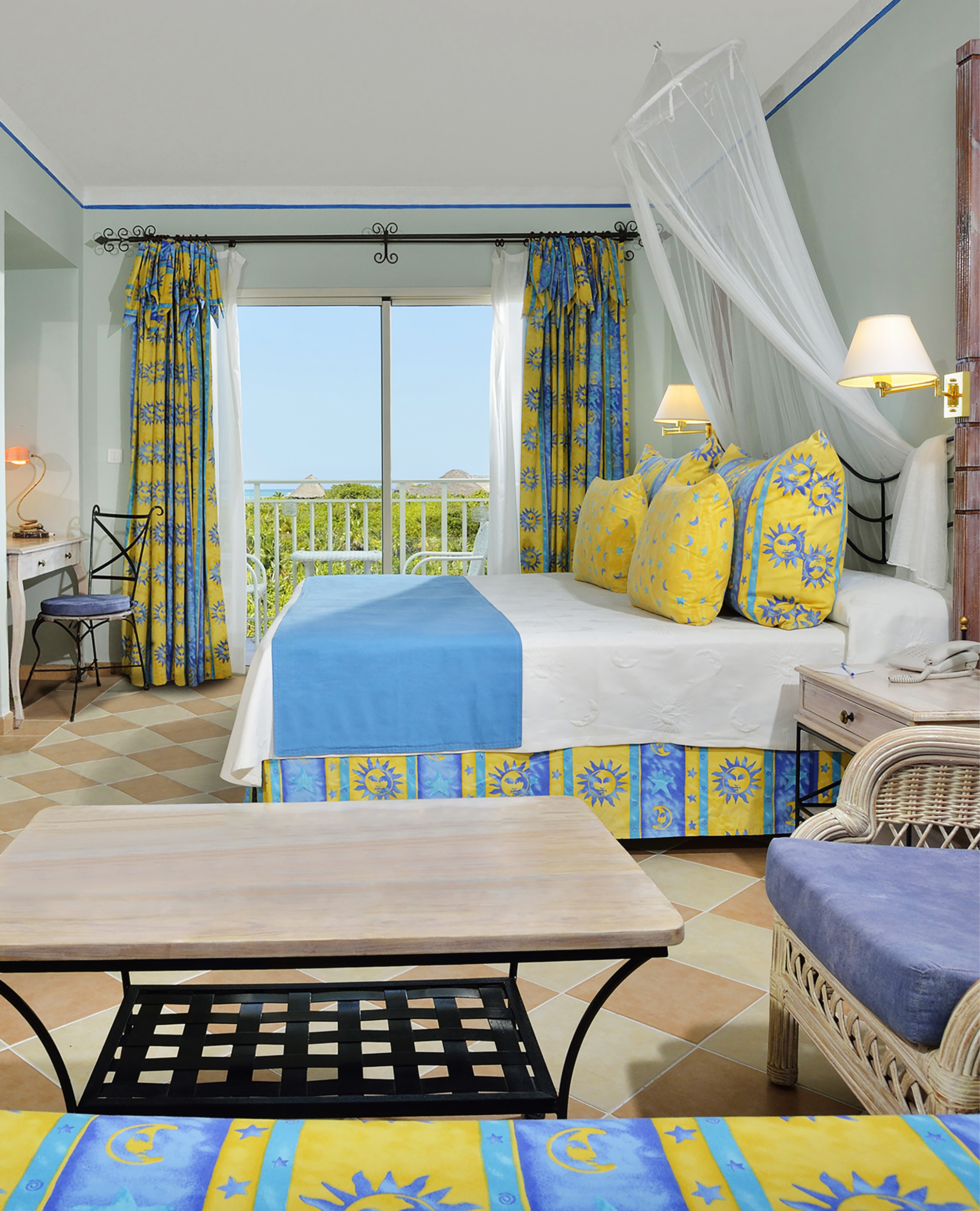 a room with a bed and chairs