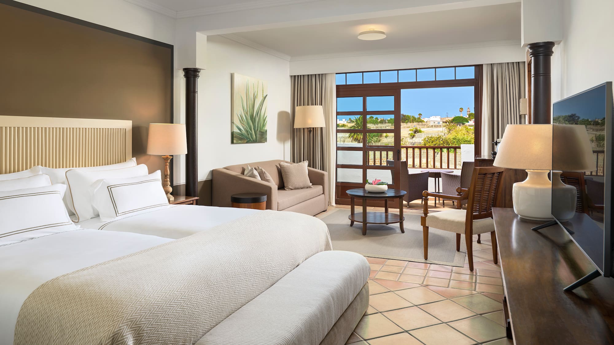 a room with two beds and a table and chairs