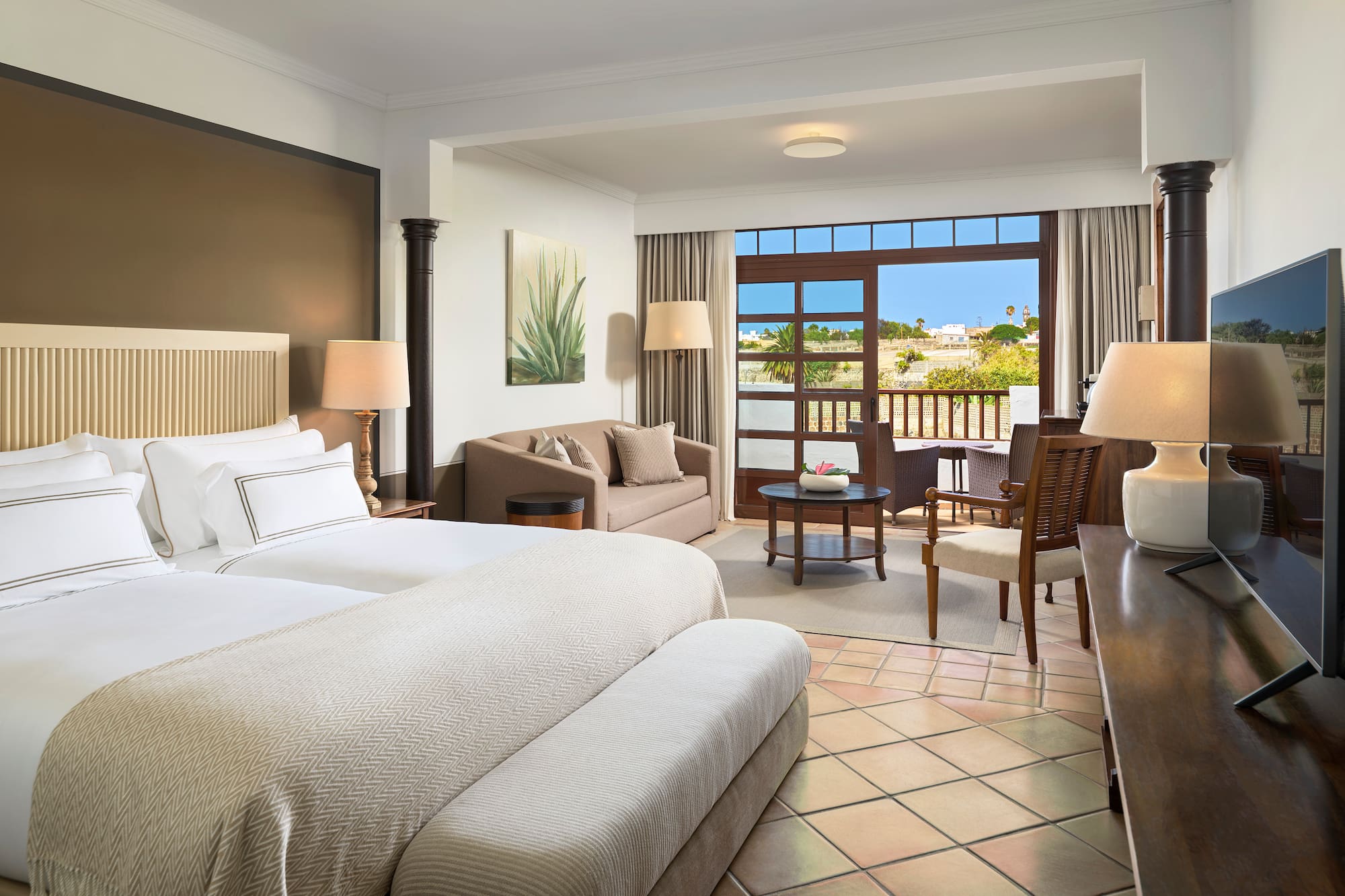 a room with two beds and a table and chairs