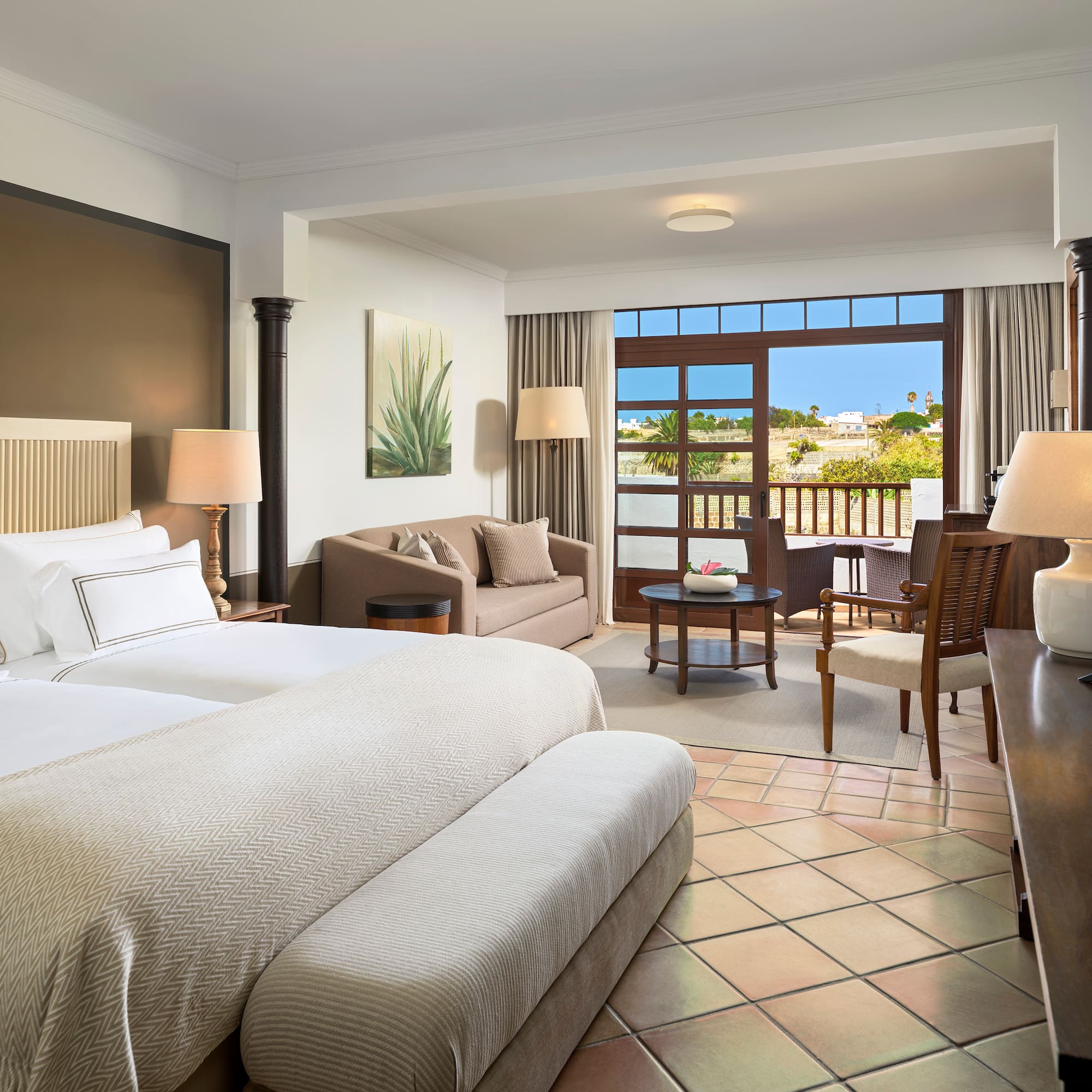 a room with two beds and a table and chairs