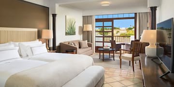 a room with two beds and a table and chairs