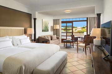 a room with two beds and a table and chairs