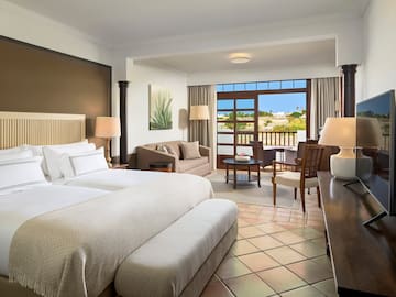 a room with two beds and a table and chairs