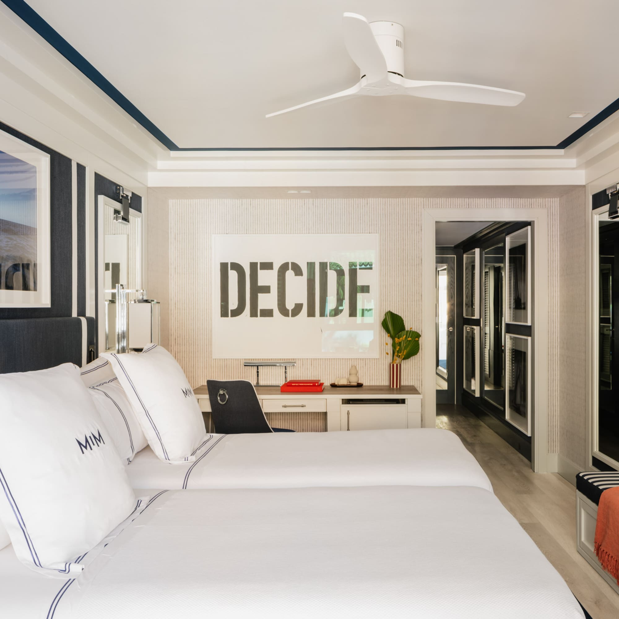 a room with two beds and a ceiling fan