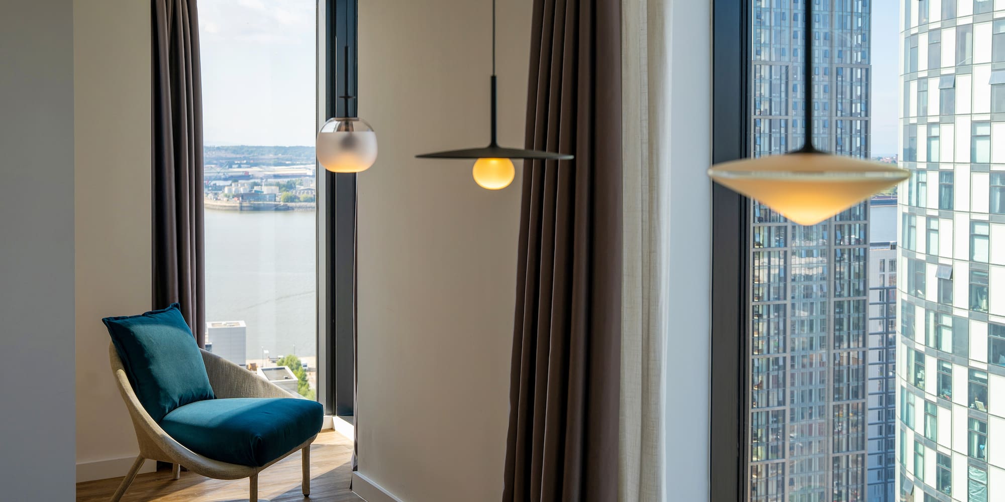 a room with a chair and a table and chairs by a window