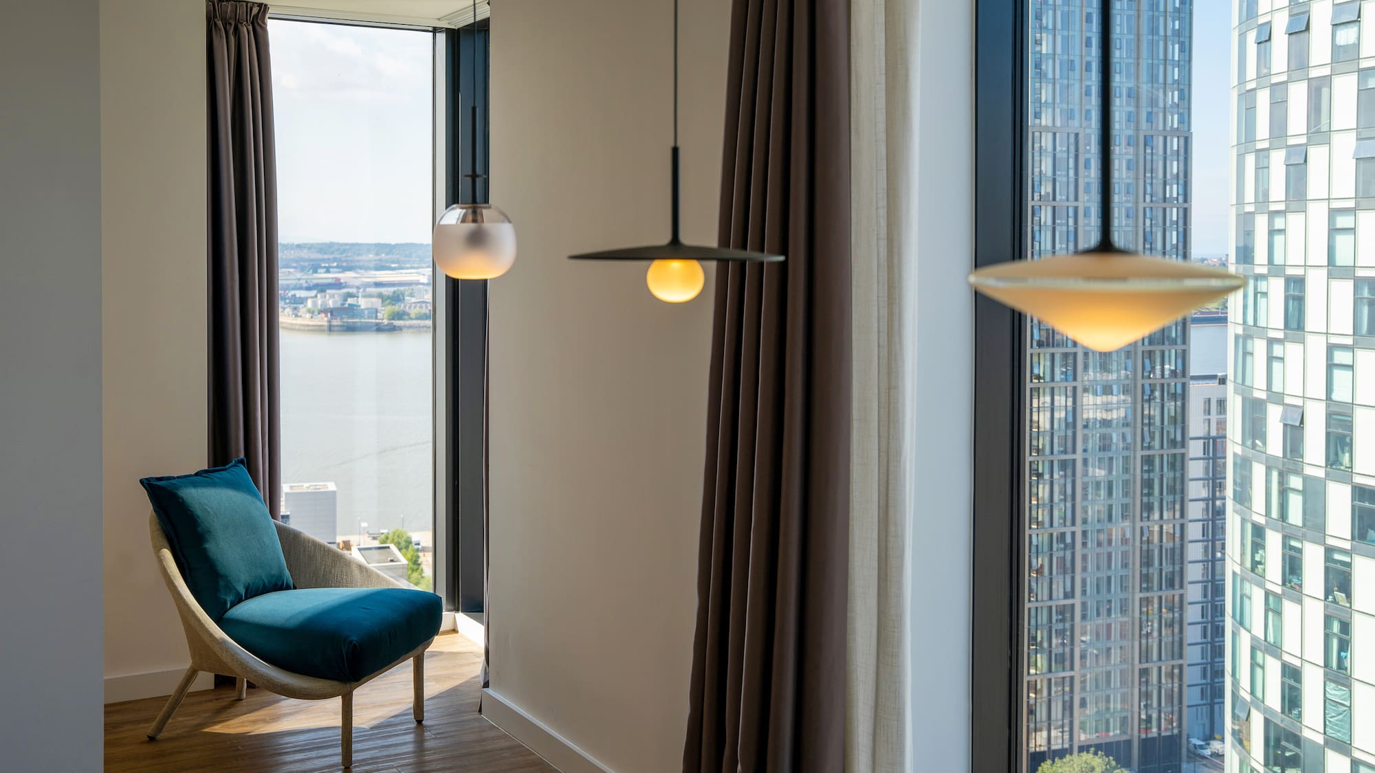 a room with a chair and a table and chairs by a window