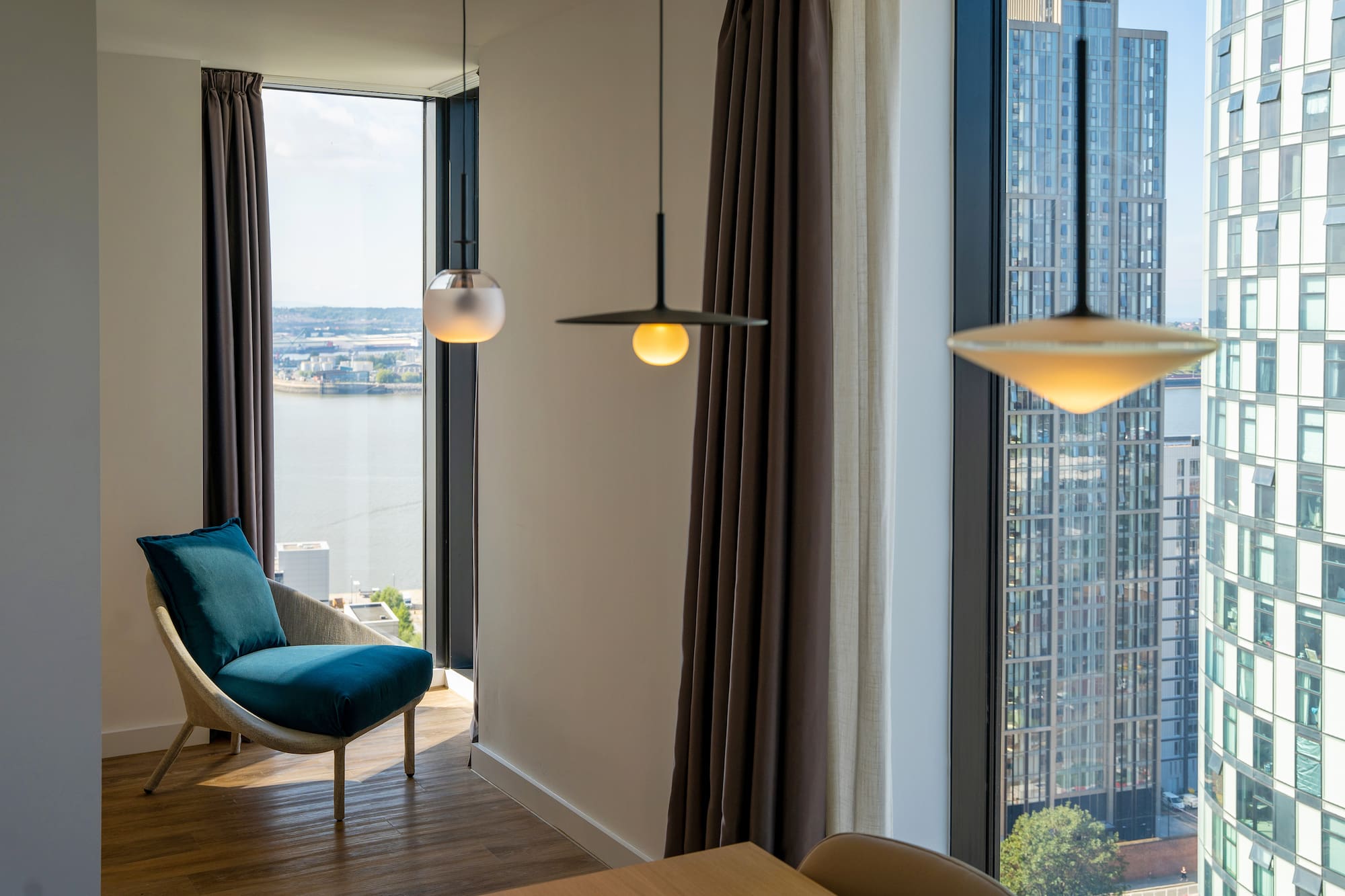 a room with a chair and a table and chairs by a window