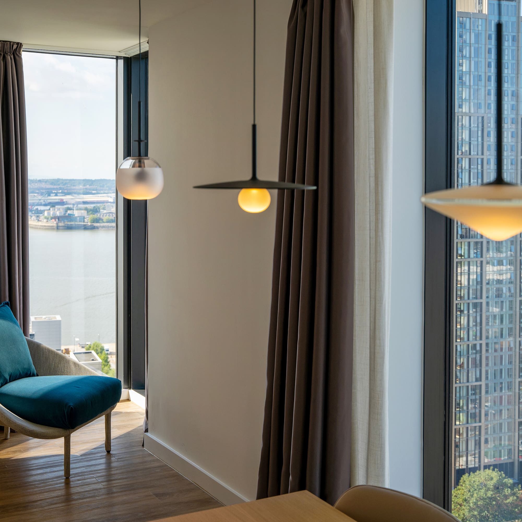 a room with a chair and a table and chairs by a window