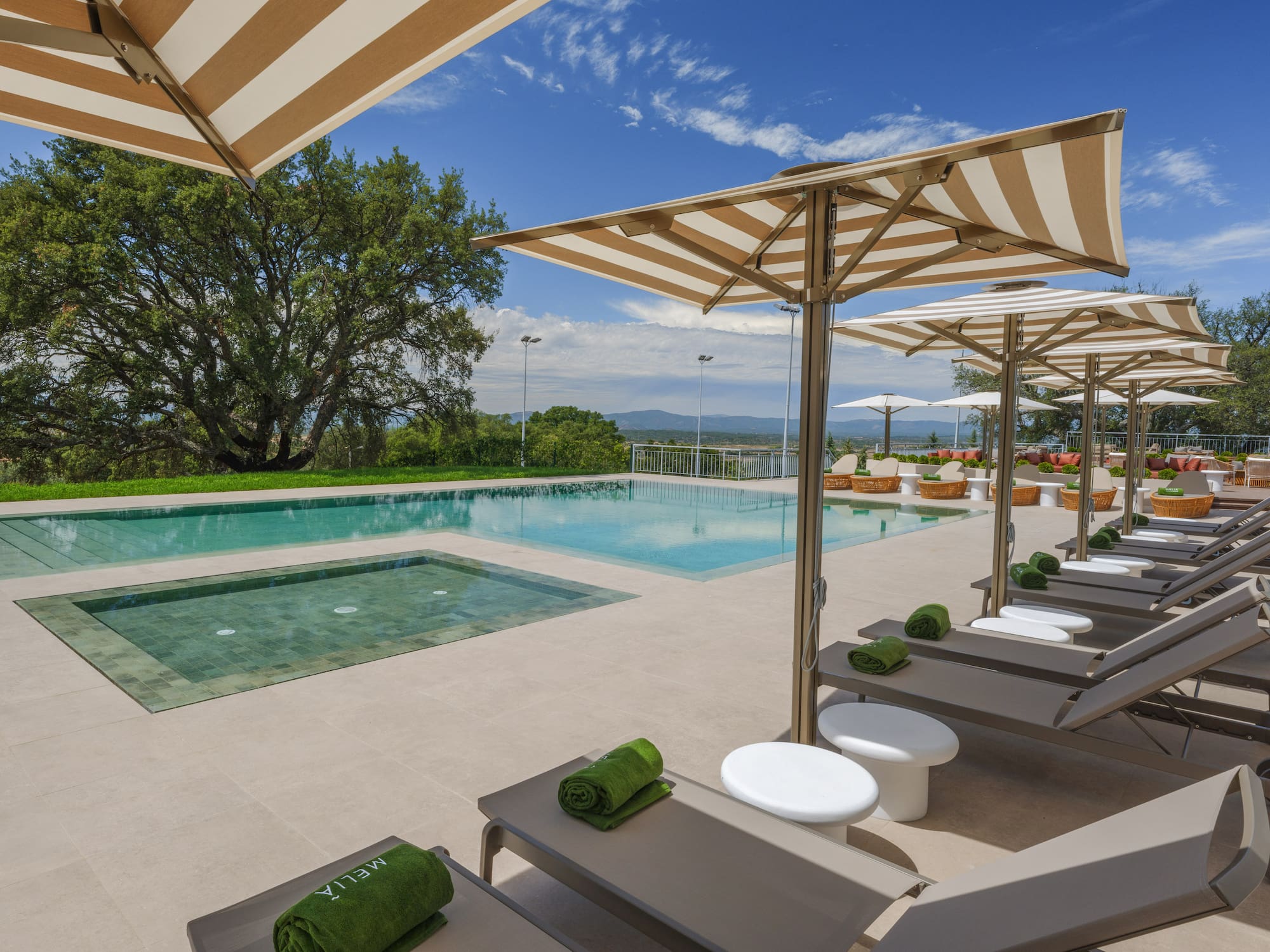 a pool with lounge chairs and umbrellas