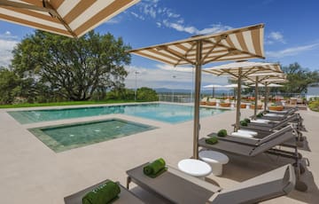 a pool with lounge chairs and umbrellas