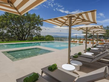 a pool with lounge chairs and umbrellas