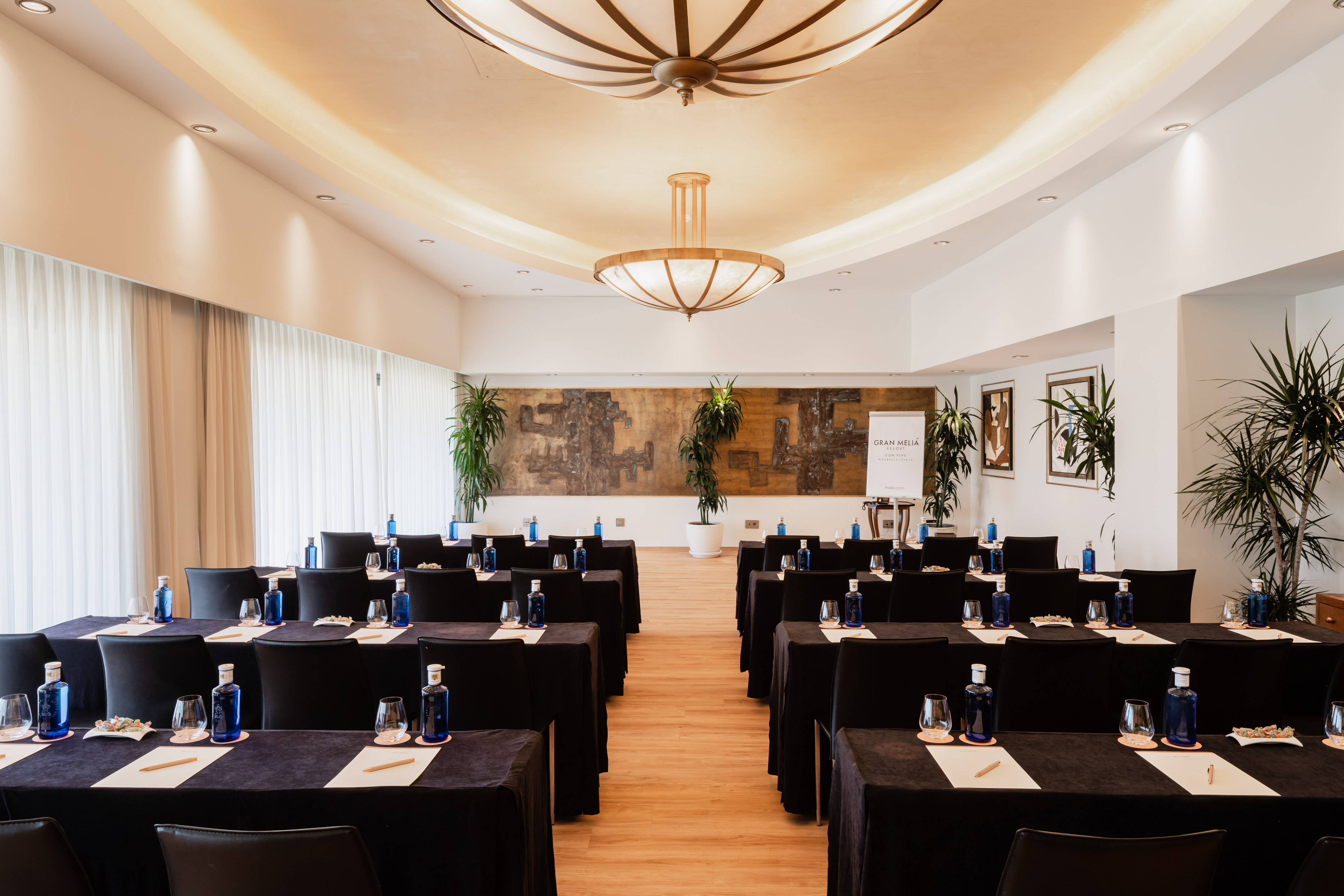 Gran Meliá meeting room, black tables with water bottles, ready for events.