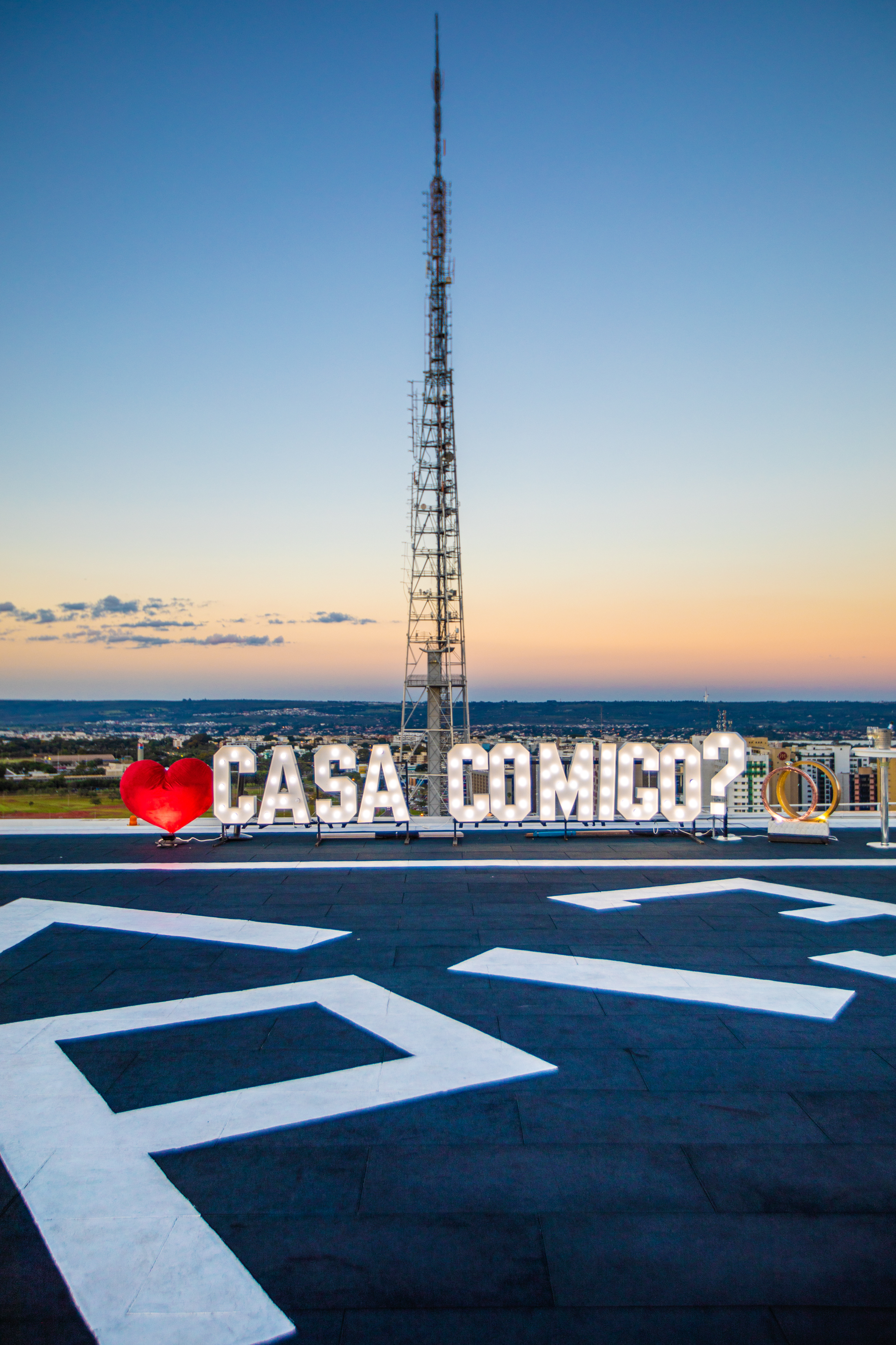 a sign on a roof with a tower in the background