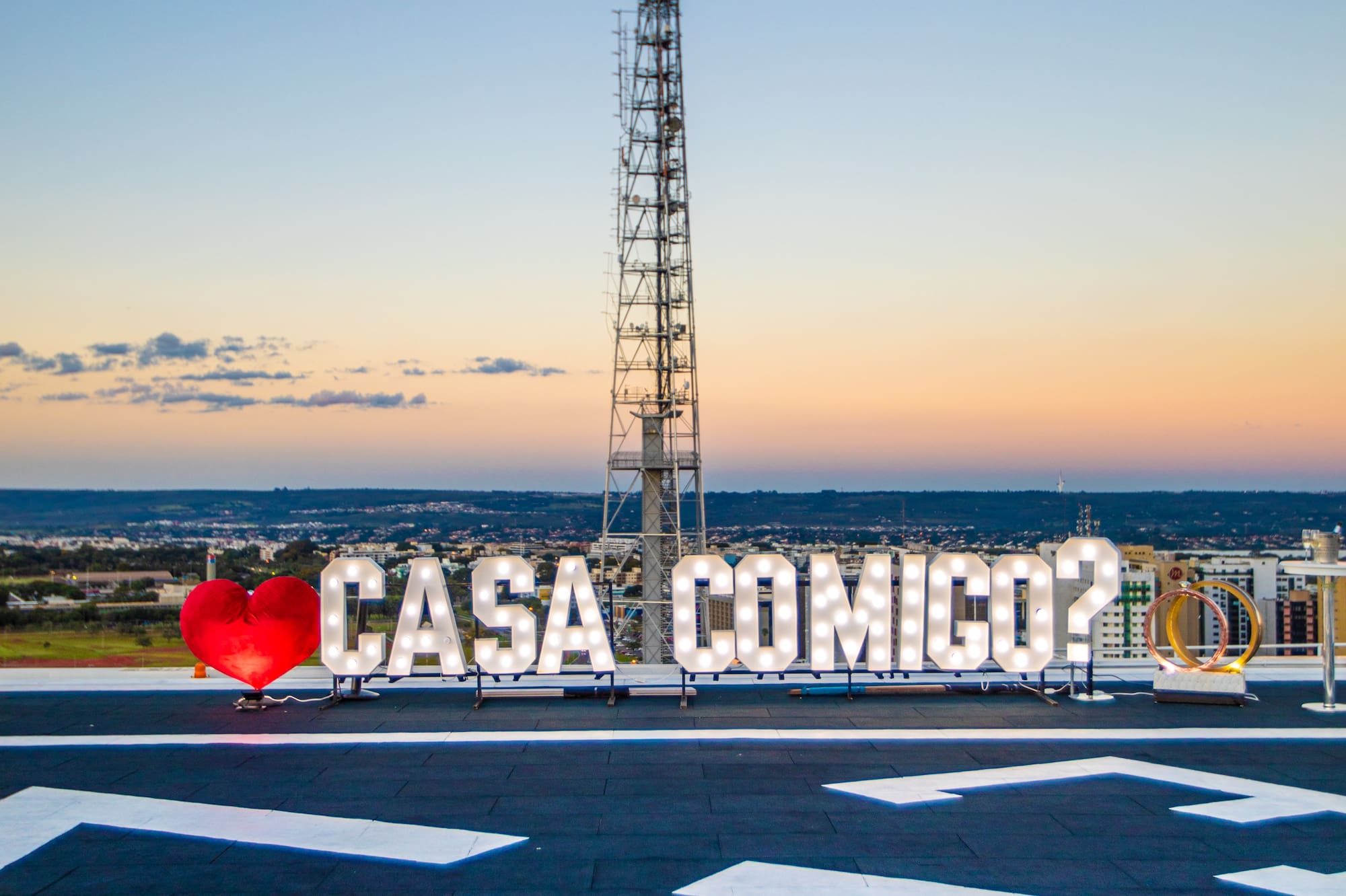a sign on a roof with a tower in the background