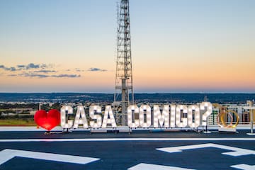 a sign on a roof with a tower in the background
