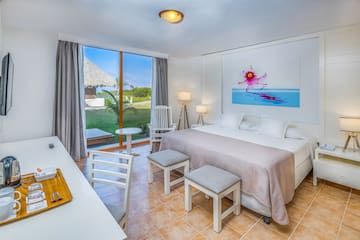a bedroom with a bed and chairs and a table
