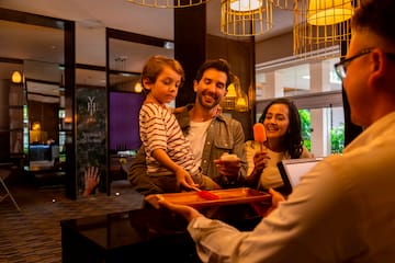 a man giving a tray of food to a family