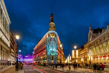 a city street with lights and people walking on it