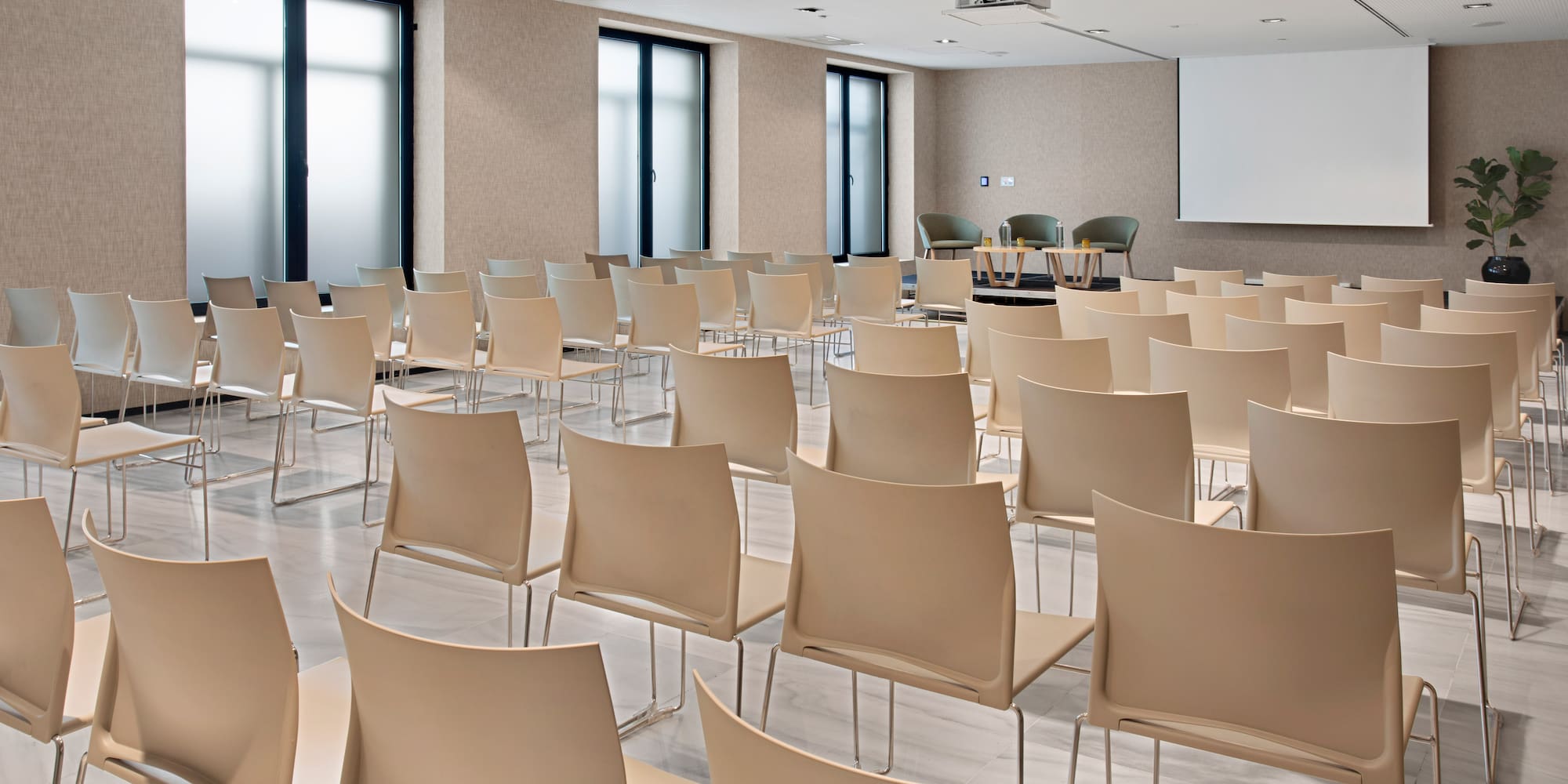 a room with many chairs and a projector screen