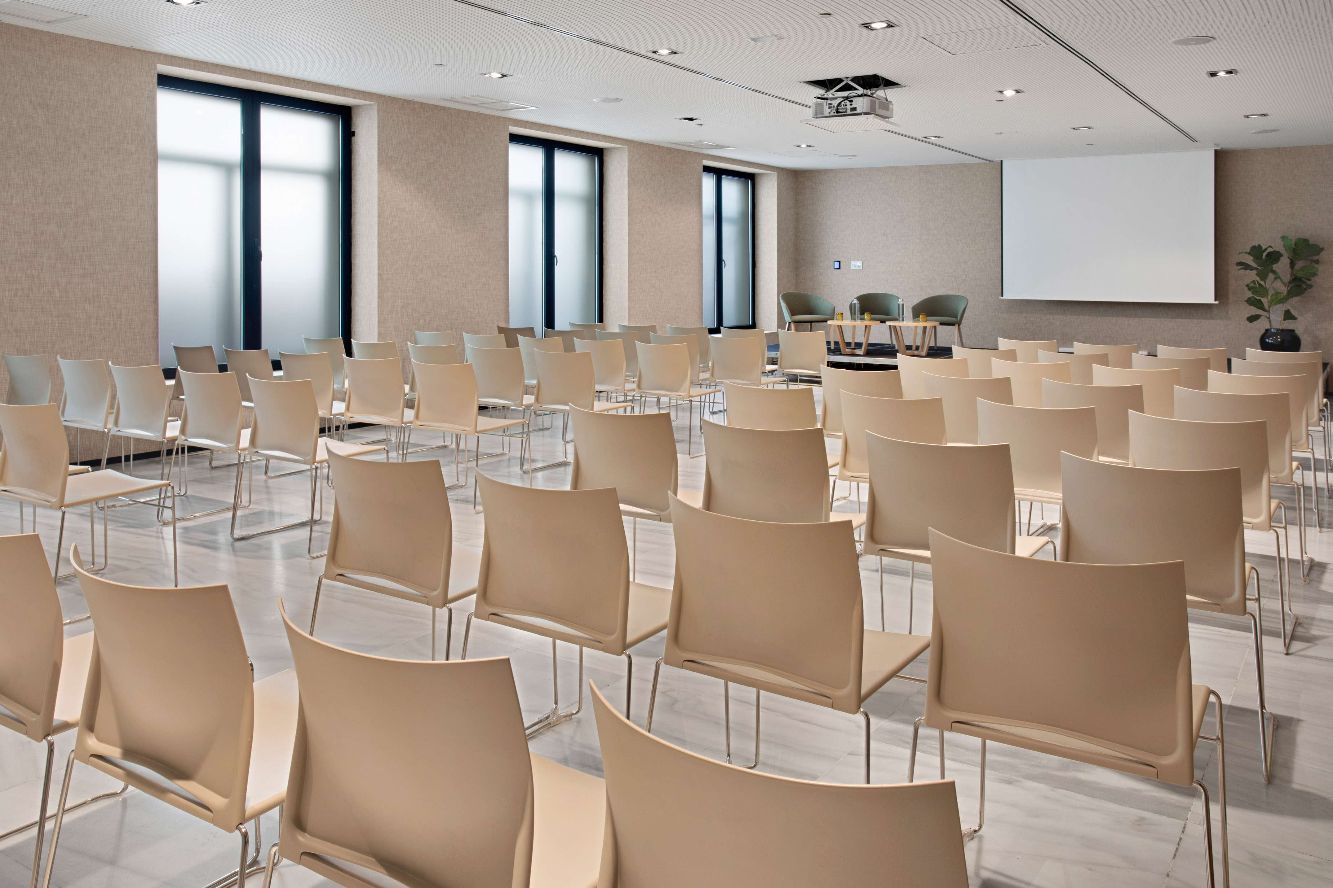 a room with many chairs and a projector screen