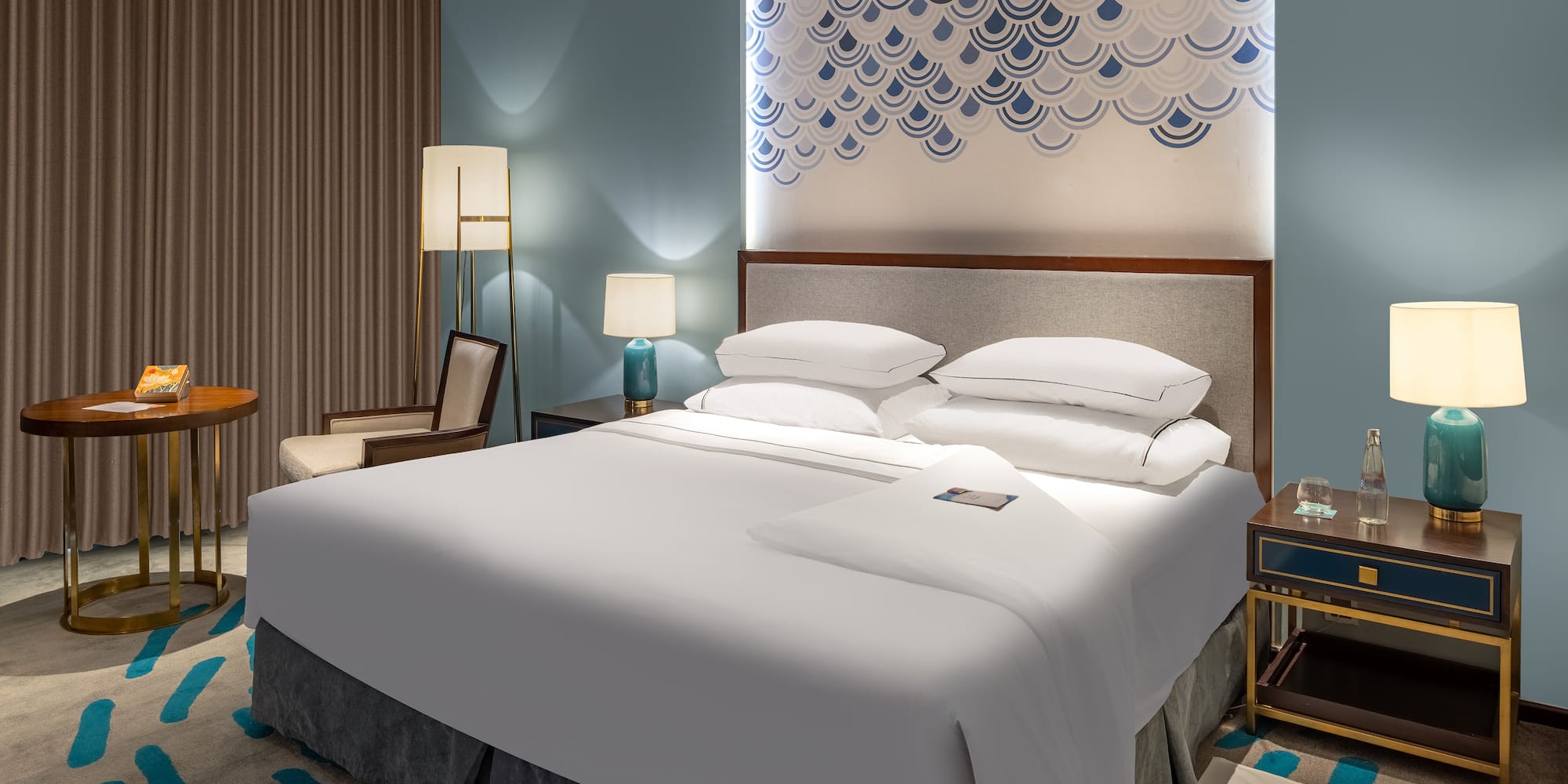 a bed with white sheets and pillows in a room