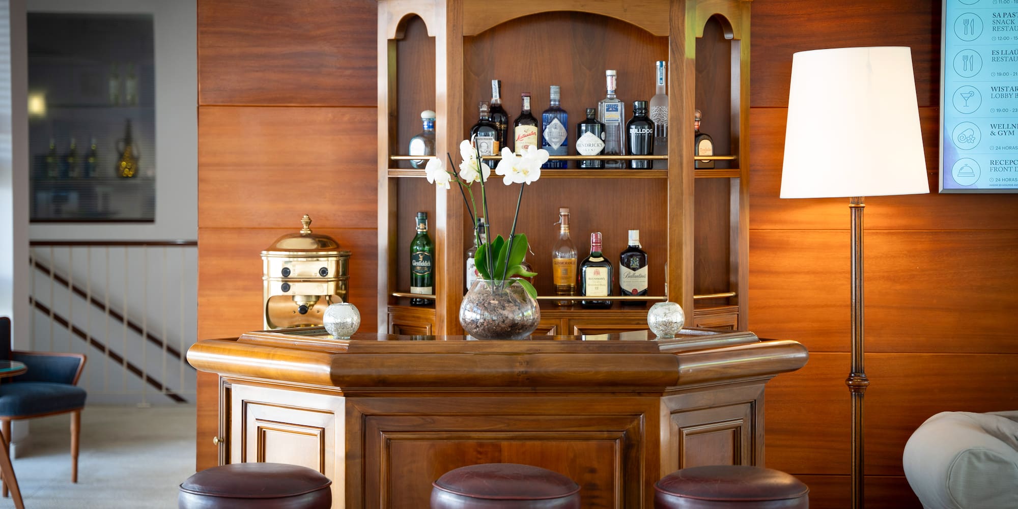 a bar with stools and a vase of flowers