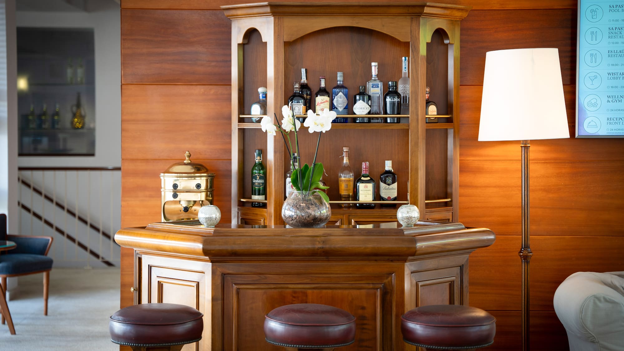a bar with stools and a vase of flowers