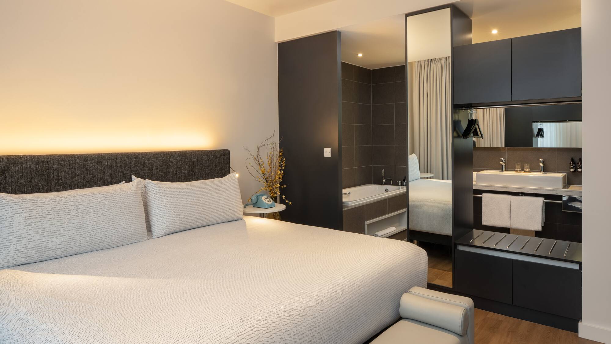 a bed with a mirror and a bathtub