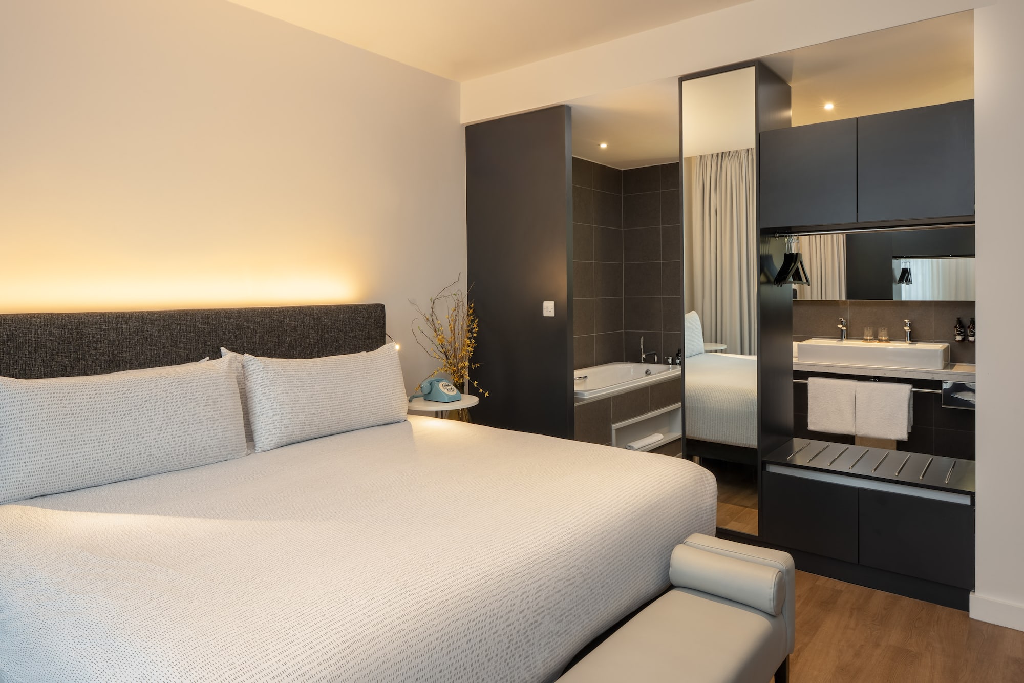 a bed with a mirror and a bathtub