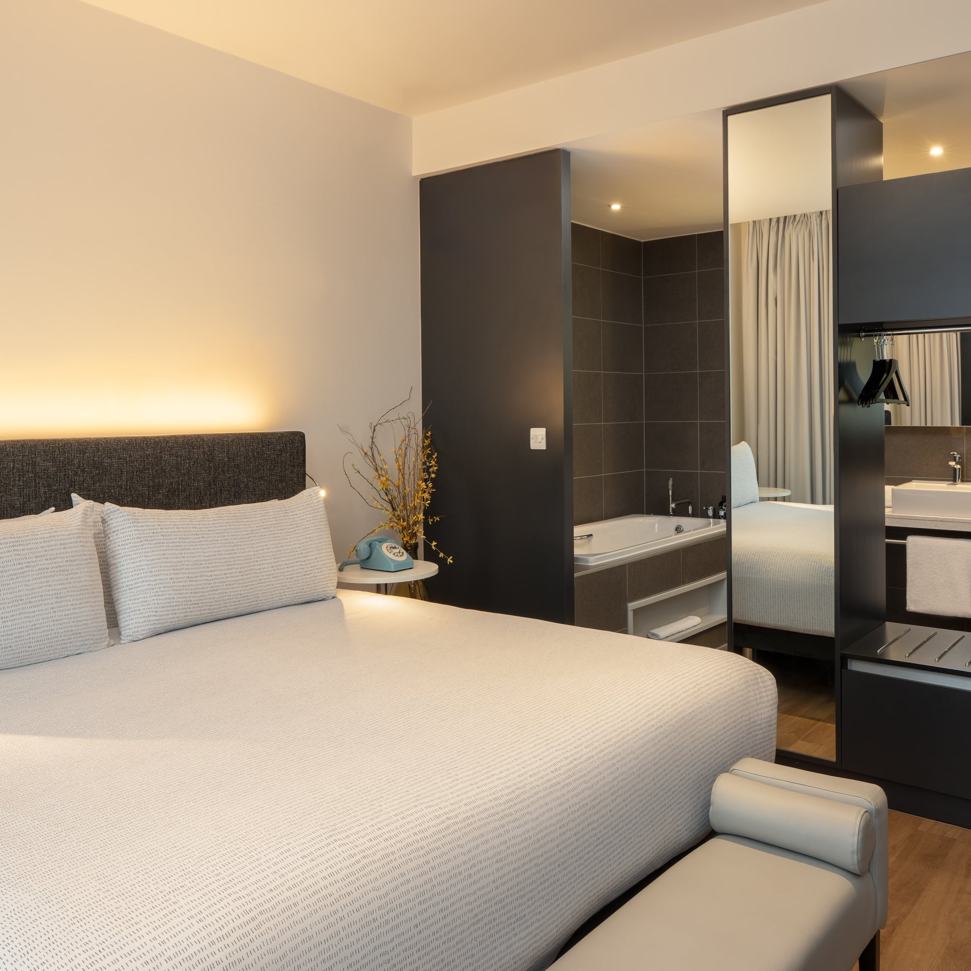 a bed with a mirror and a bathtub