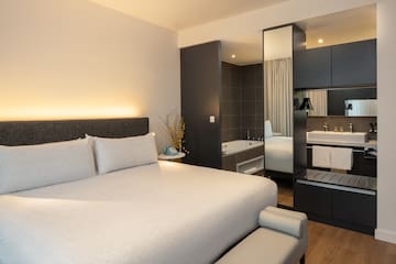 a bed with a mirror and a bathtub