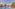 Blue tropical resort pool with palm trees, sun loungers, and hotel buildings.