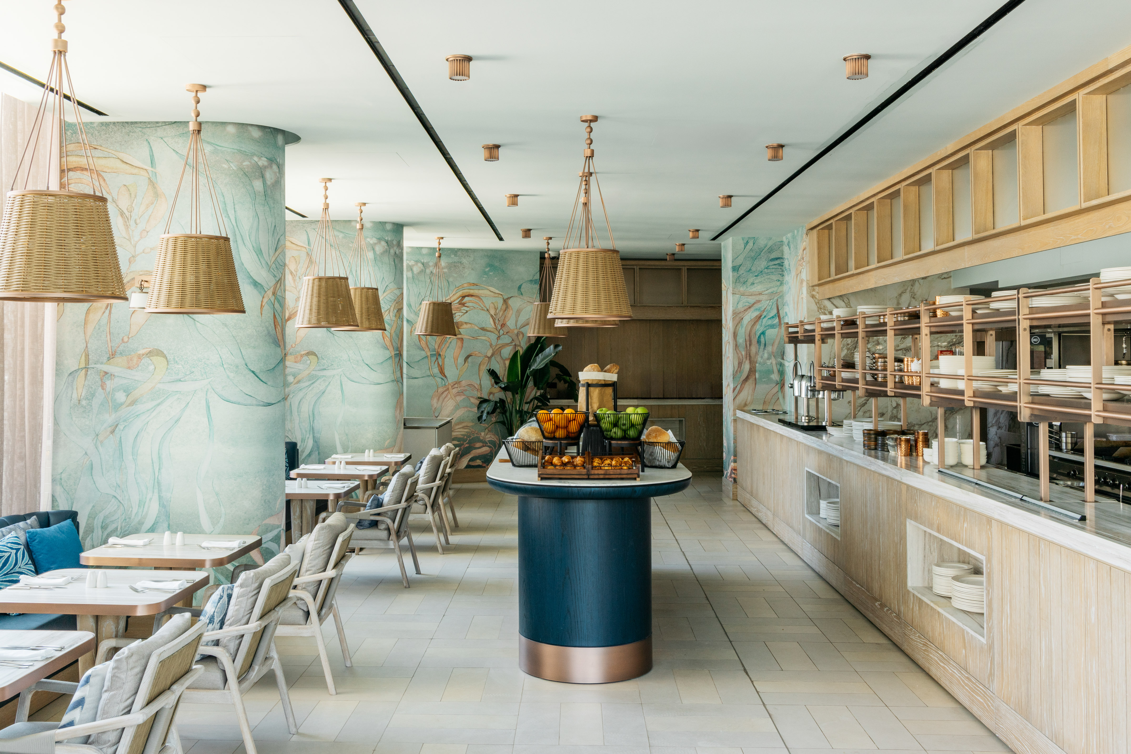 Modern hotel restaurant buffet with wicker lights and teal botanical mural.