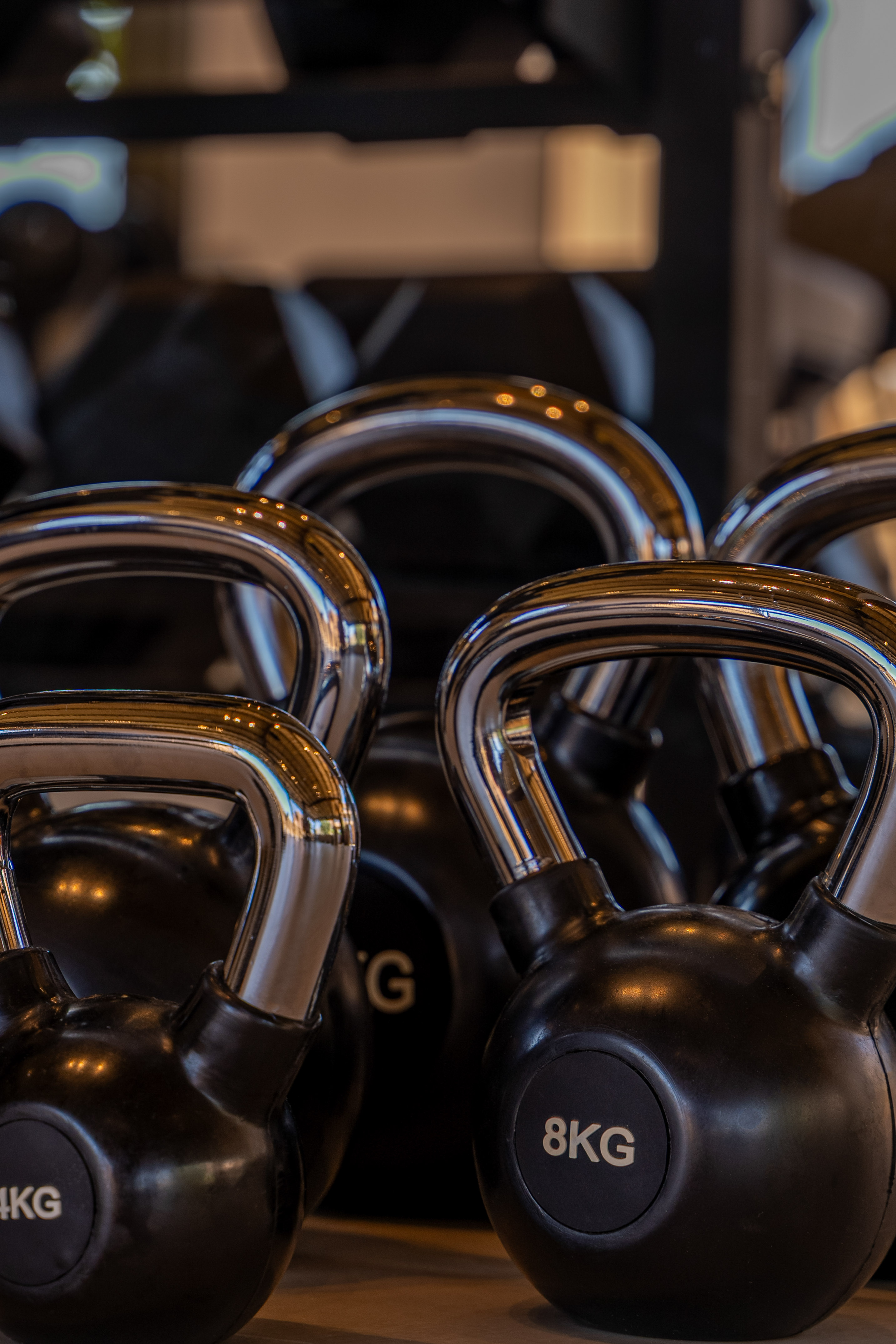Black kettlebells with chrome handles, 4KG and 8KG weights for strength training.