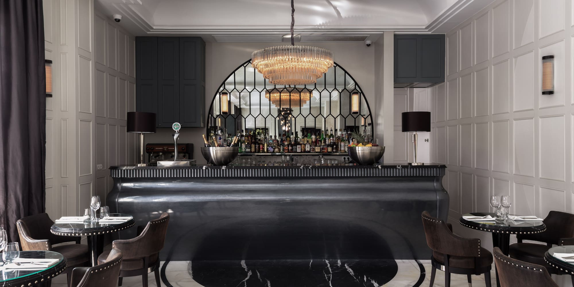 a bar with a chandelier and chairs