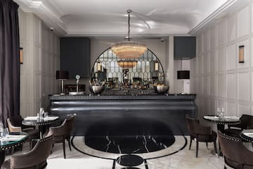 a bar with a chandelier and chairs