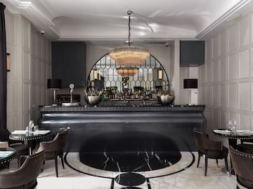 a bar with a chandelier and chairs