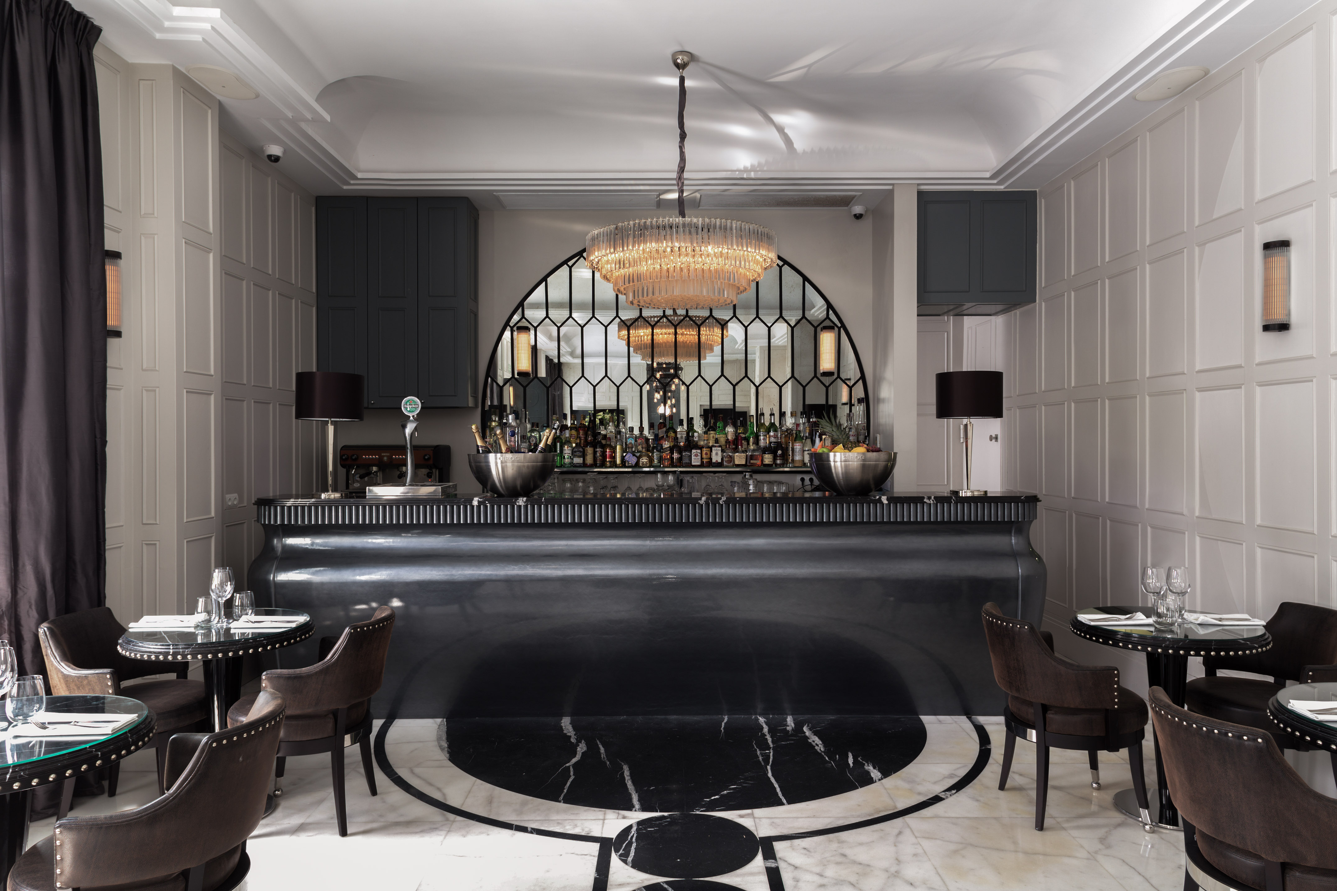 a bar with a chandelier and chairs