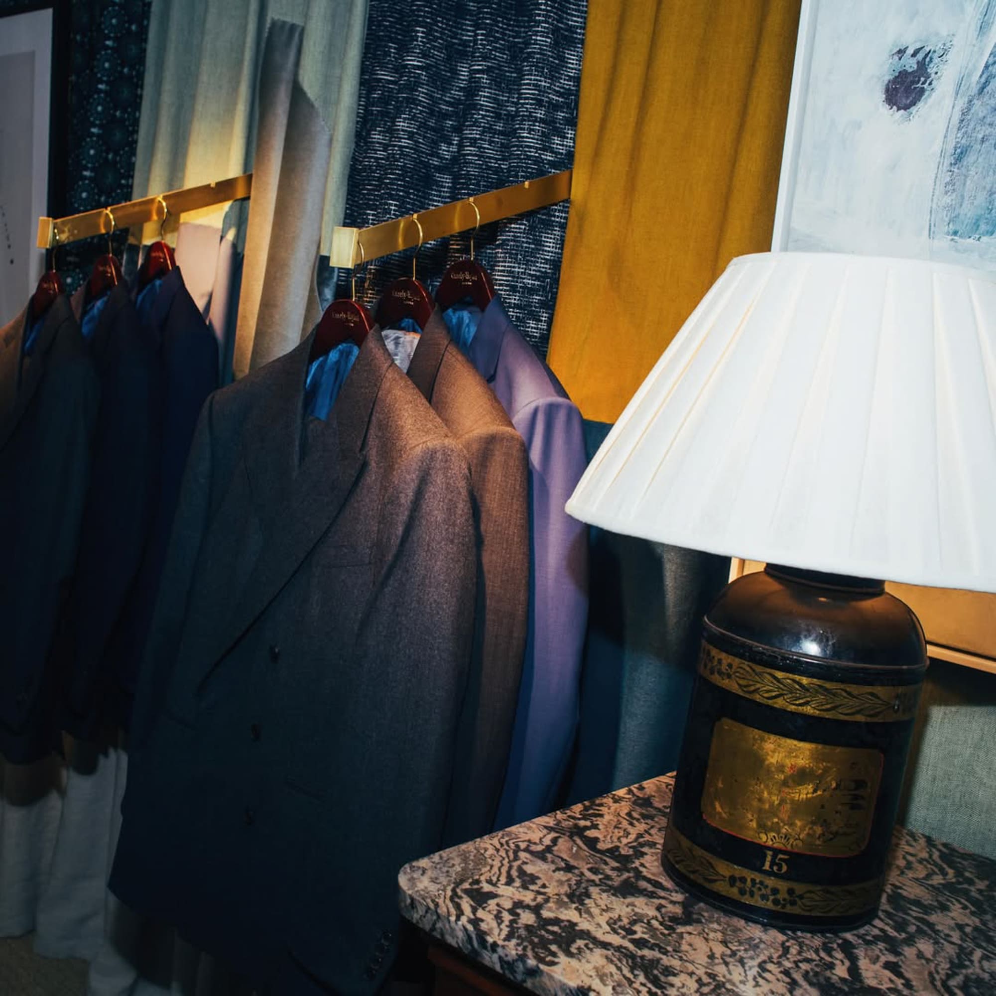 a room with suits on swingers and a lamp