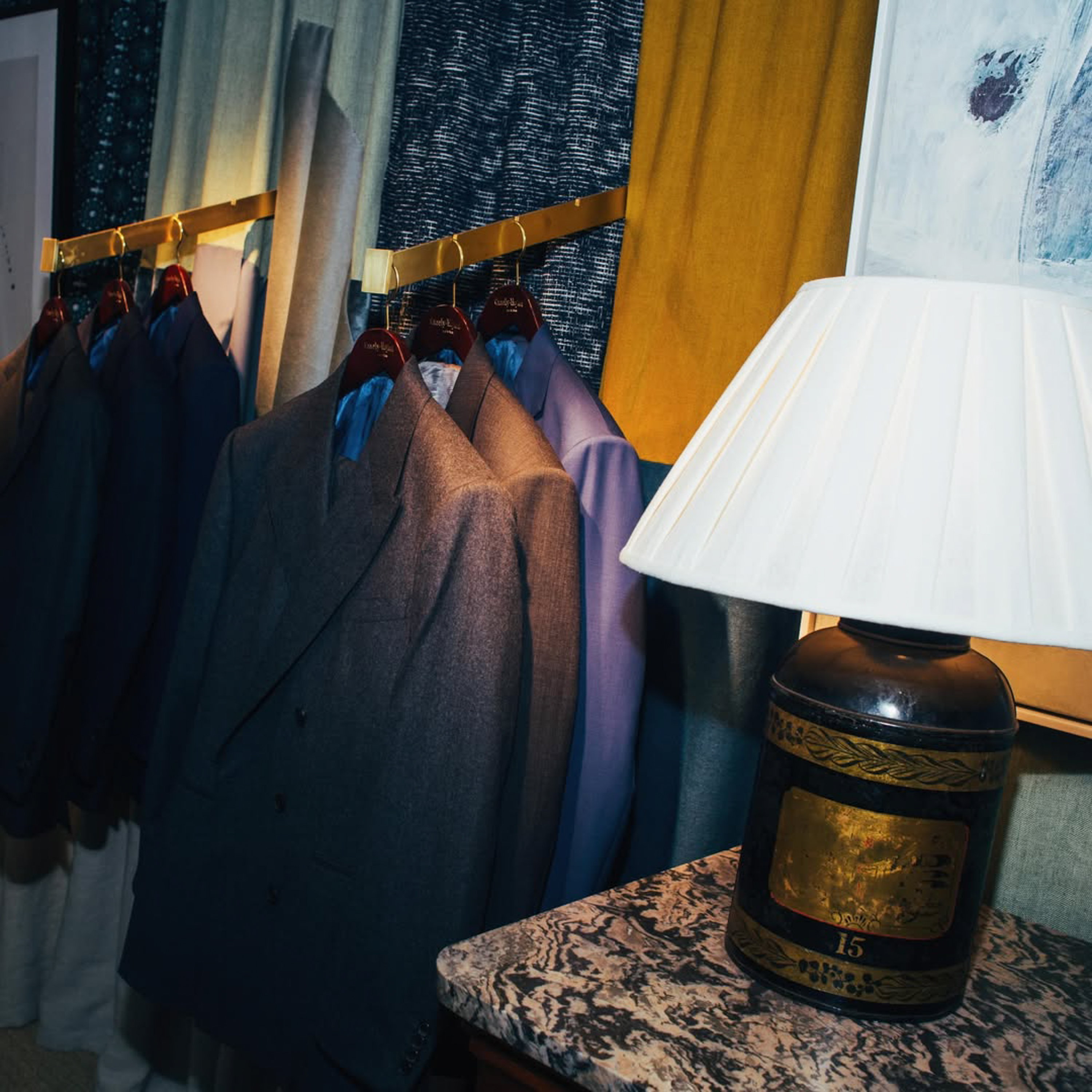 a room with suits on swingers and a lamp