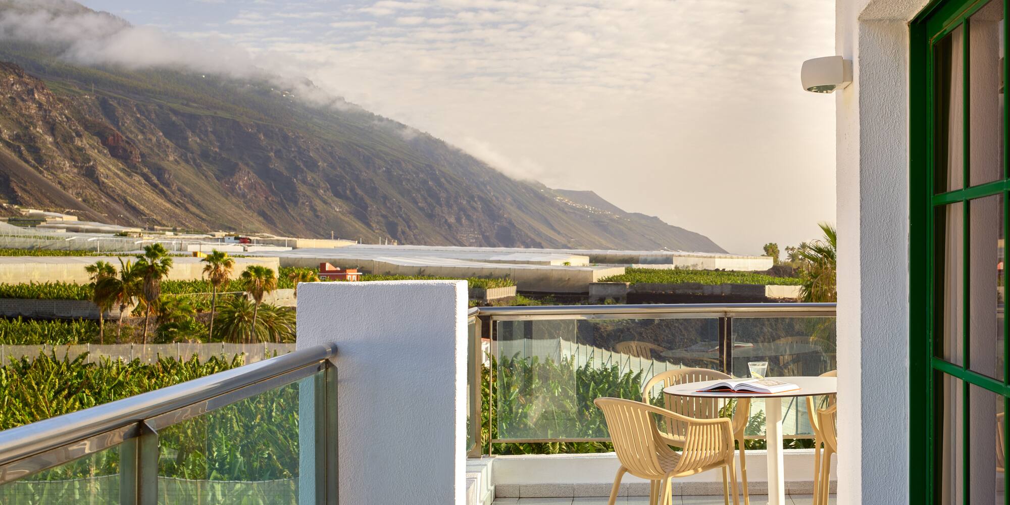 a table and chairs on a balcony overlooking a mountain