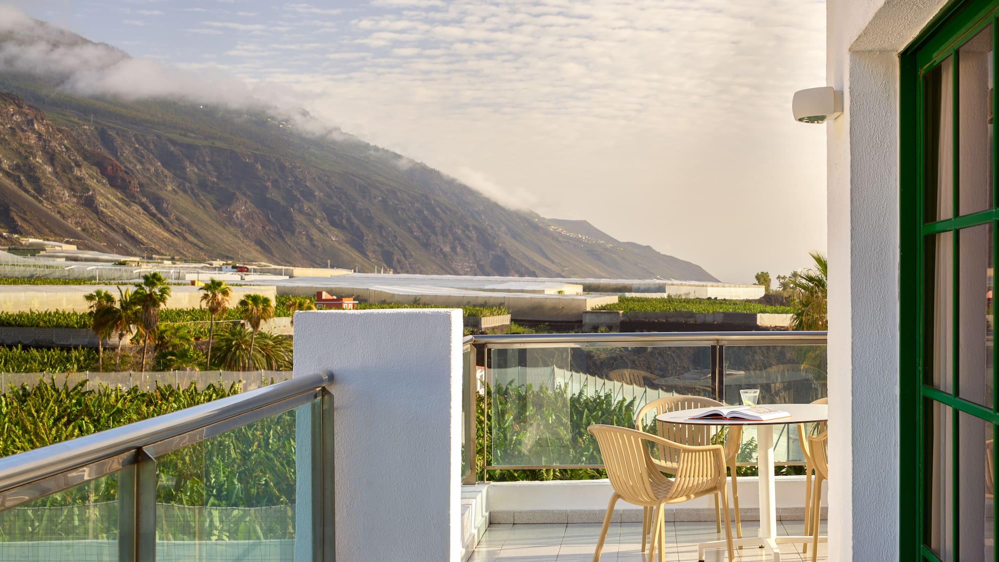 a table and chairs on a balcony overlooking a mountain
