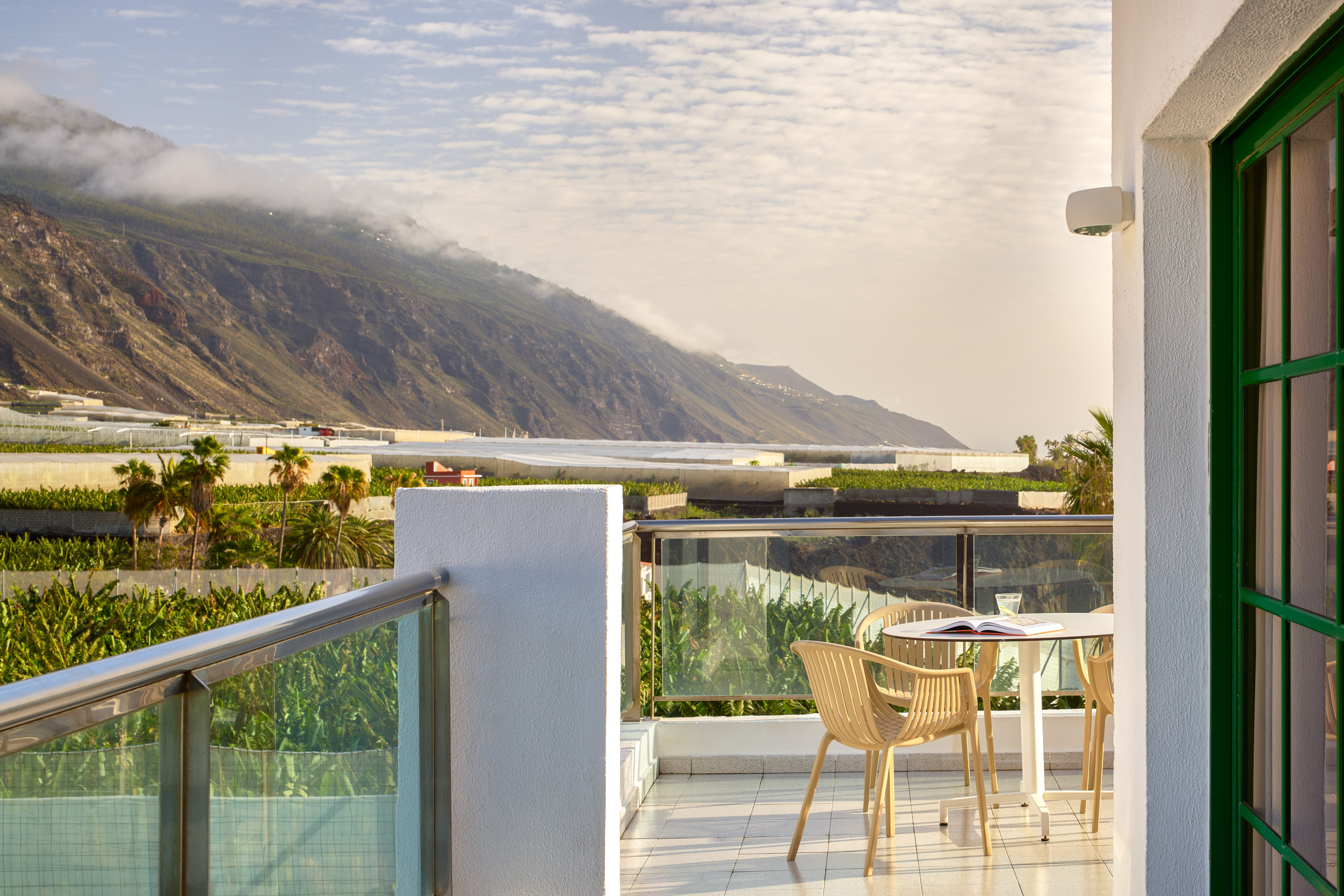 a table and chairs on a balcony overlooking a mountain