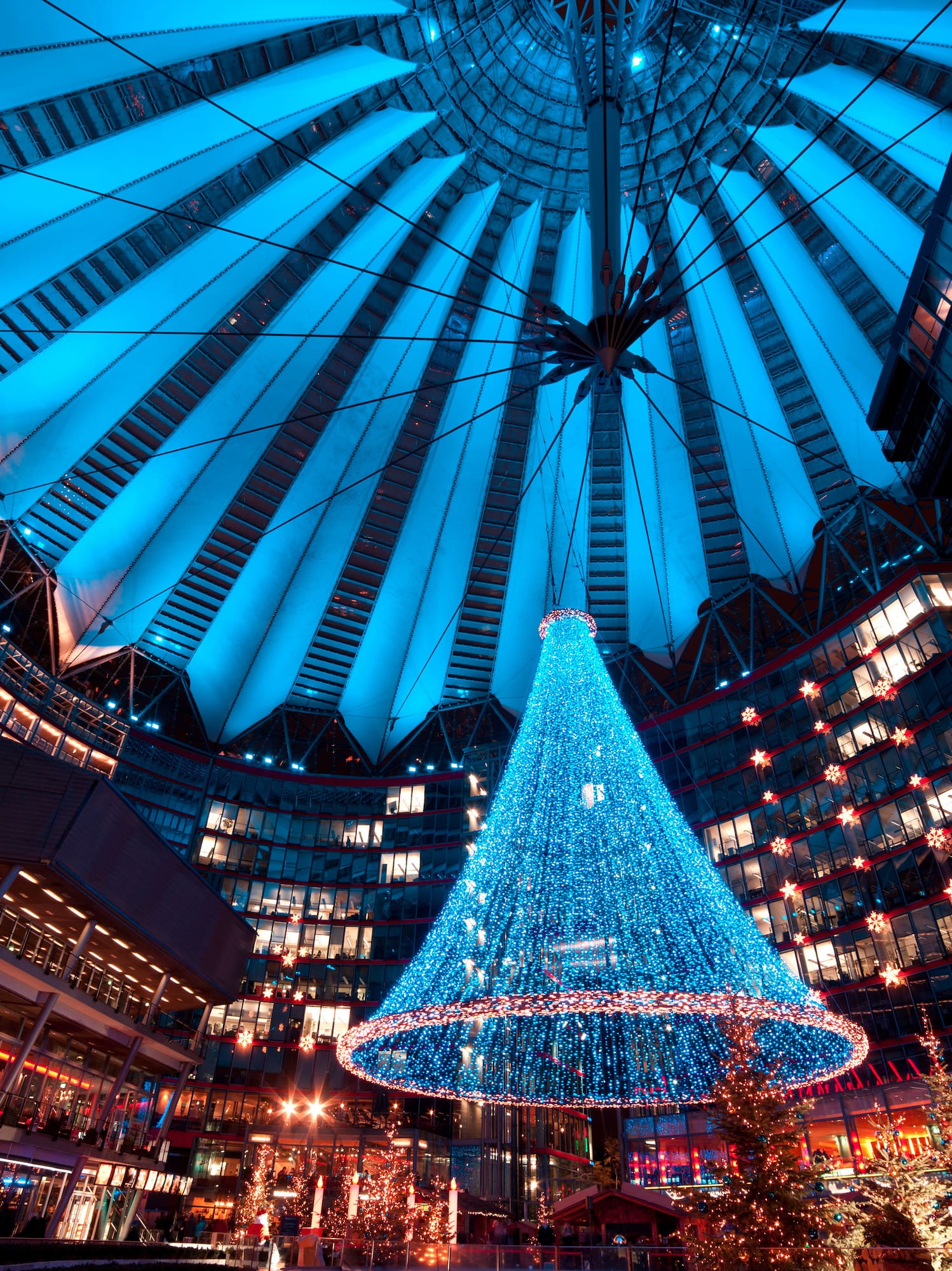 a large blue christmas tree in a large building