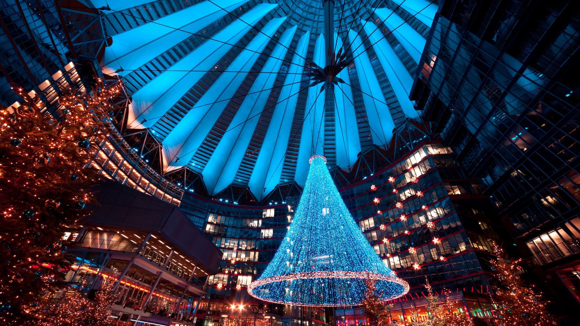 a large blue christmas tree in a large building